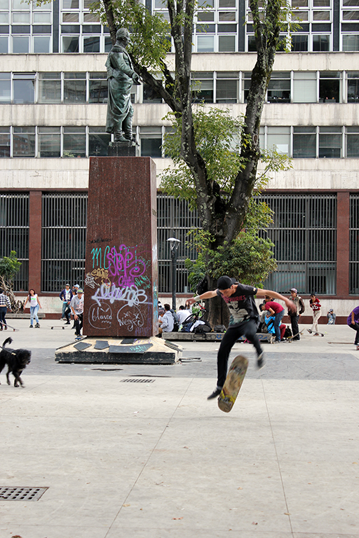 Skateboarder Attempts Kickflip Parque Santander Plaza en Bogotaá, Colombia