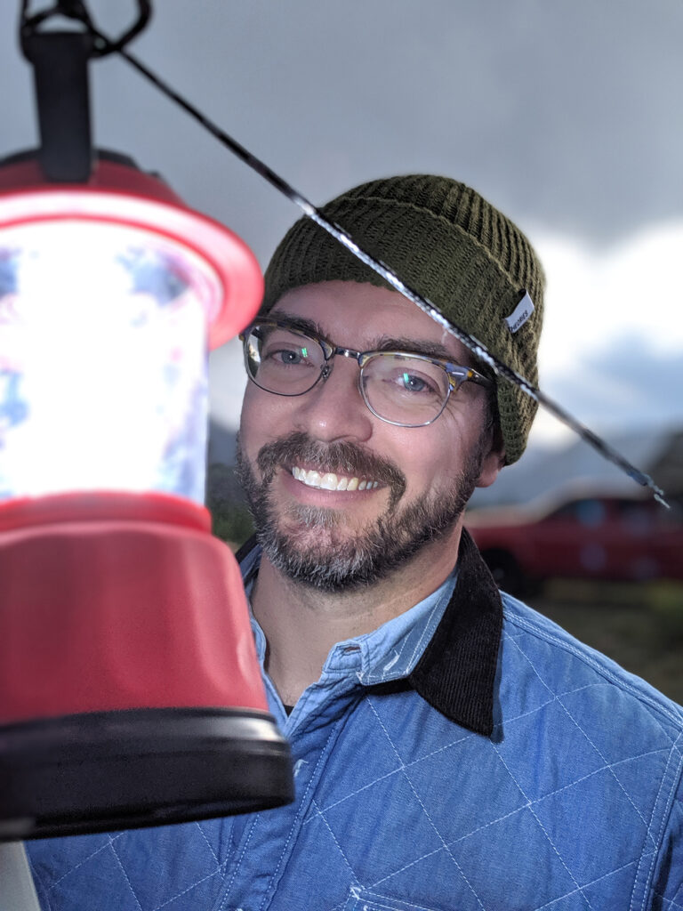 Luke Illuminated by Lantern at Campsite