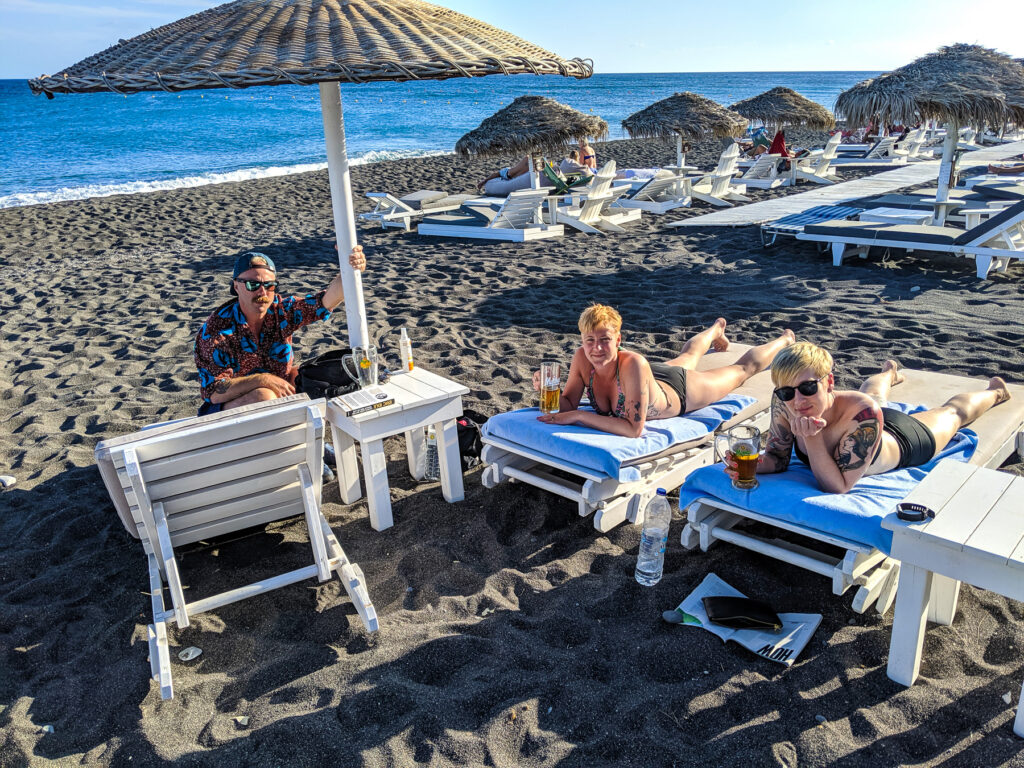 Lounging on Perissa Beach in Santorini with Beers