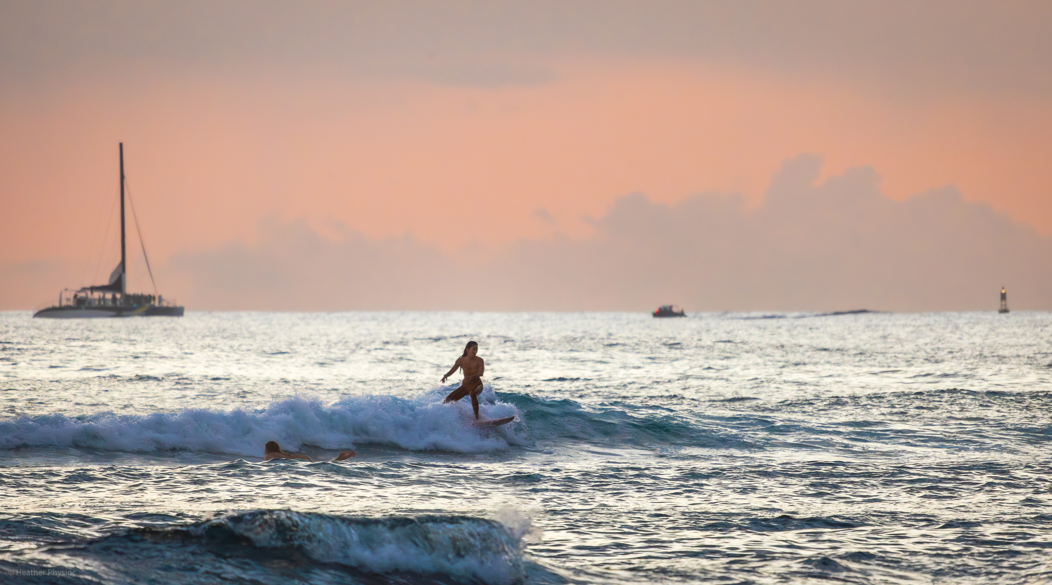 Woman surfing at sunset near Waikiki beach