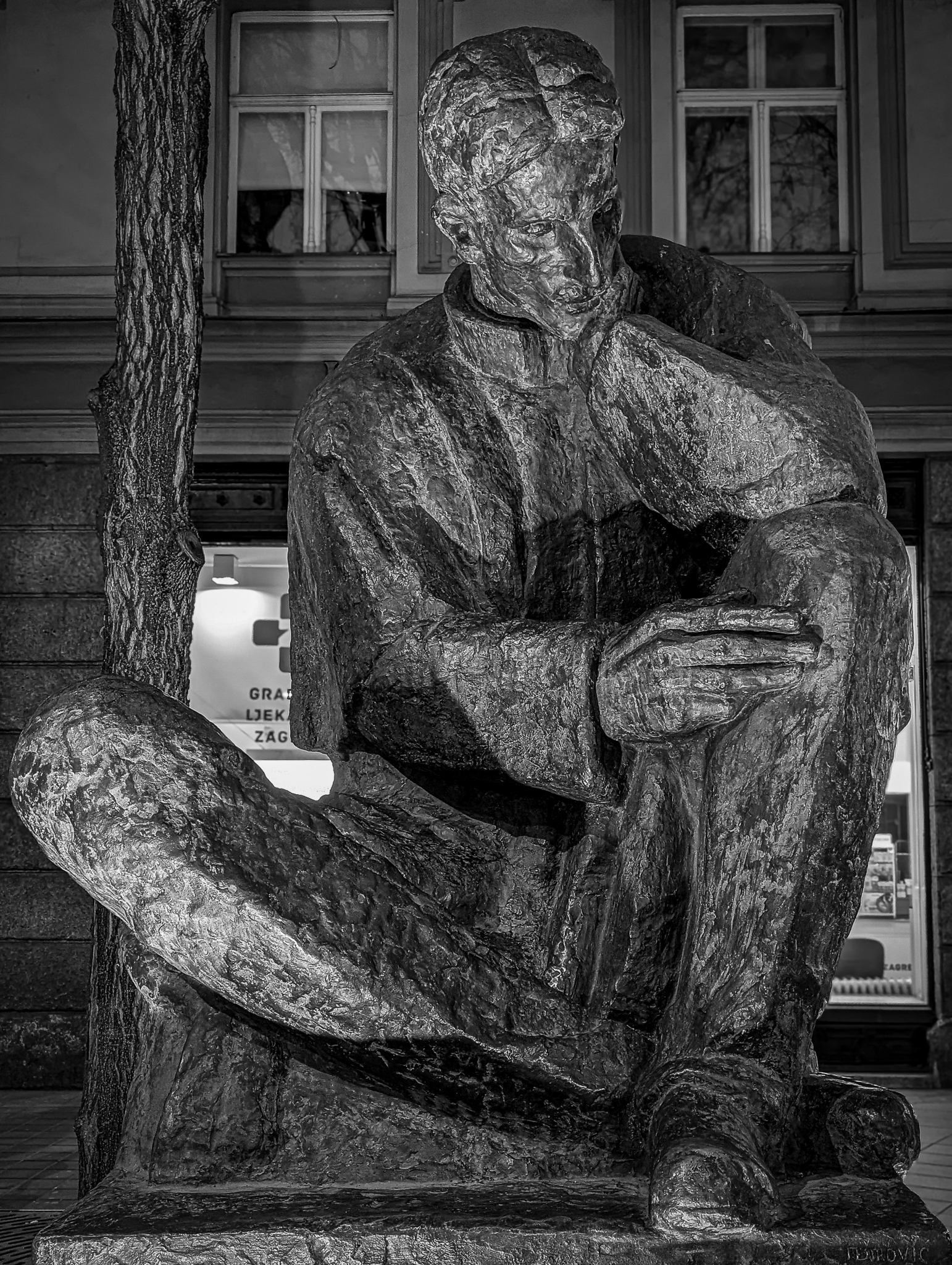 Black-and-white photo of pensive Nikola Tesla statue on the streets of Zagreb, Croatia